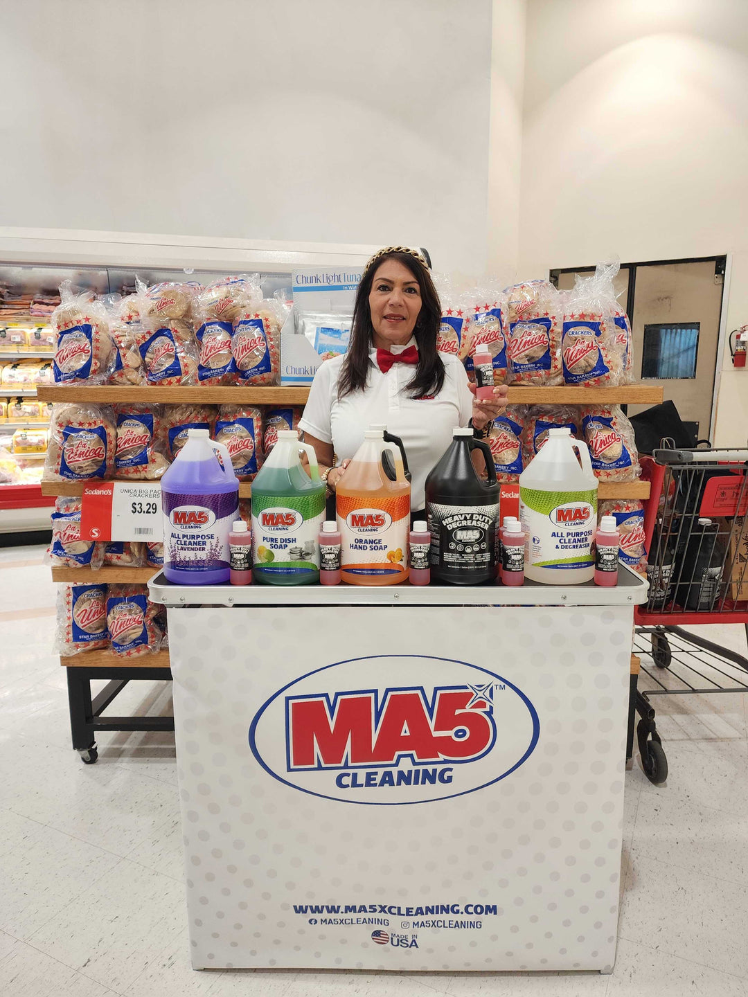 Person standing behind a counter with various cleaning products in a store setting