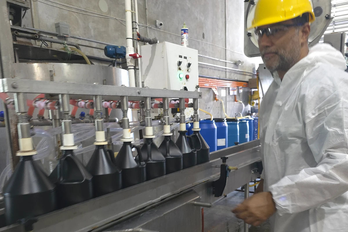 Person in a factory setting operating machinery with safety gear