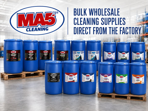 Multiple blue MA5X bulk 55 Gallon Drums arranged on wooden pallets in a warehouse setting, with the MA5X logo and the text BULK WHOLESALE CLEANING SUPPLIES DIRECT FROM THE FACTORY overlaid at the top.