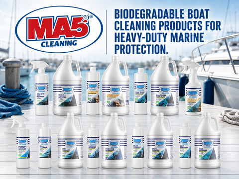 A collection of MA5X biodegradable boat cleaning products, including various sizes of white plastic jugs and spray bottles, arranged on a boat deck with a marina background. The image features the MA5X logo and text at the top.